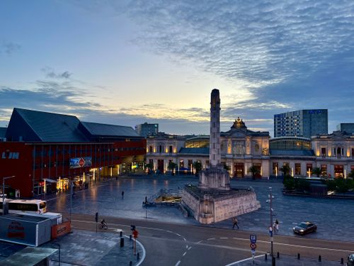 Free Leuven's historic town hall and square at twilight, featuring a dramatic sky and soft evening lights. Stock Photo