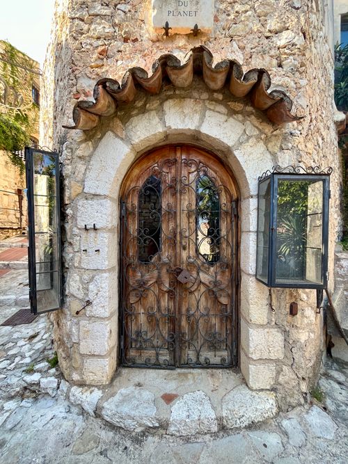 Free Charming medieval stone building entrance in Èze, France with ornate wooden door and wrought iron detailing. Stock Photo