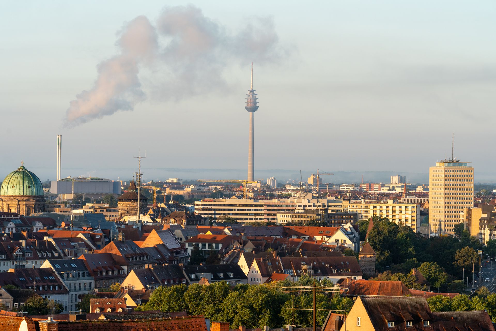 Panoramic view of Stuttgart city skyline featuring the Fernsehturm tower and city rooftops at dawn.