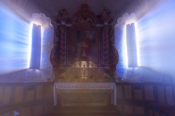 Retable baroque illuminé entre des fenêtres ensoleillées