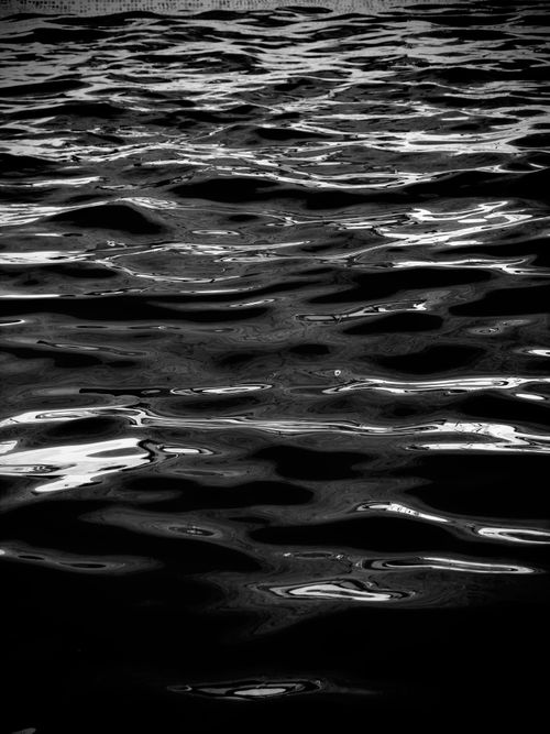 Free A calming black and white reflection of gentle water ripples. Stock Photo