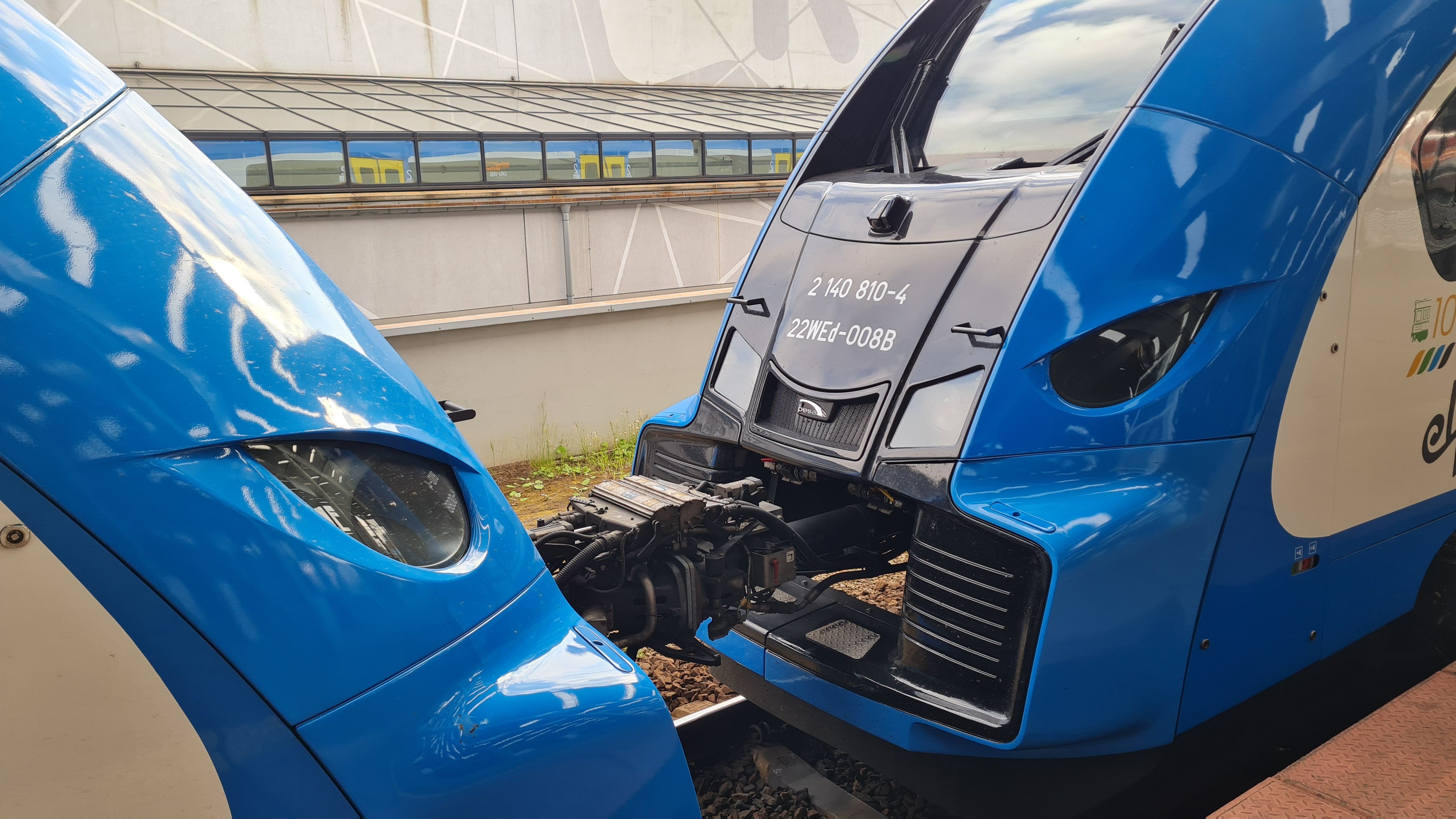 Close-up view of two blue trains connected at a station platform.