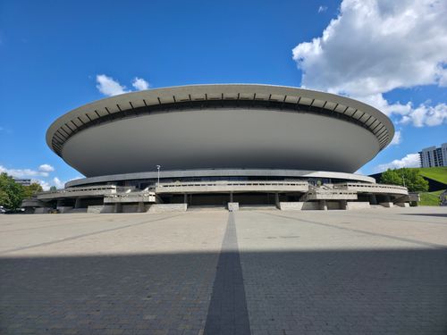 Free Front view of Spodek Arena in Katowice under a clear blue sky, showcasing its unique architecture. Stock Photo