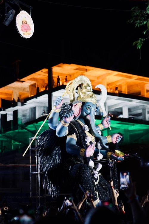 Free Vibrant statue of Lord Ganesha during a night festival celebration with illuminated building backdrop. Stock Photo
