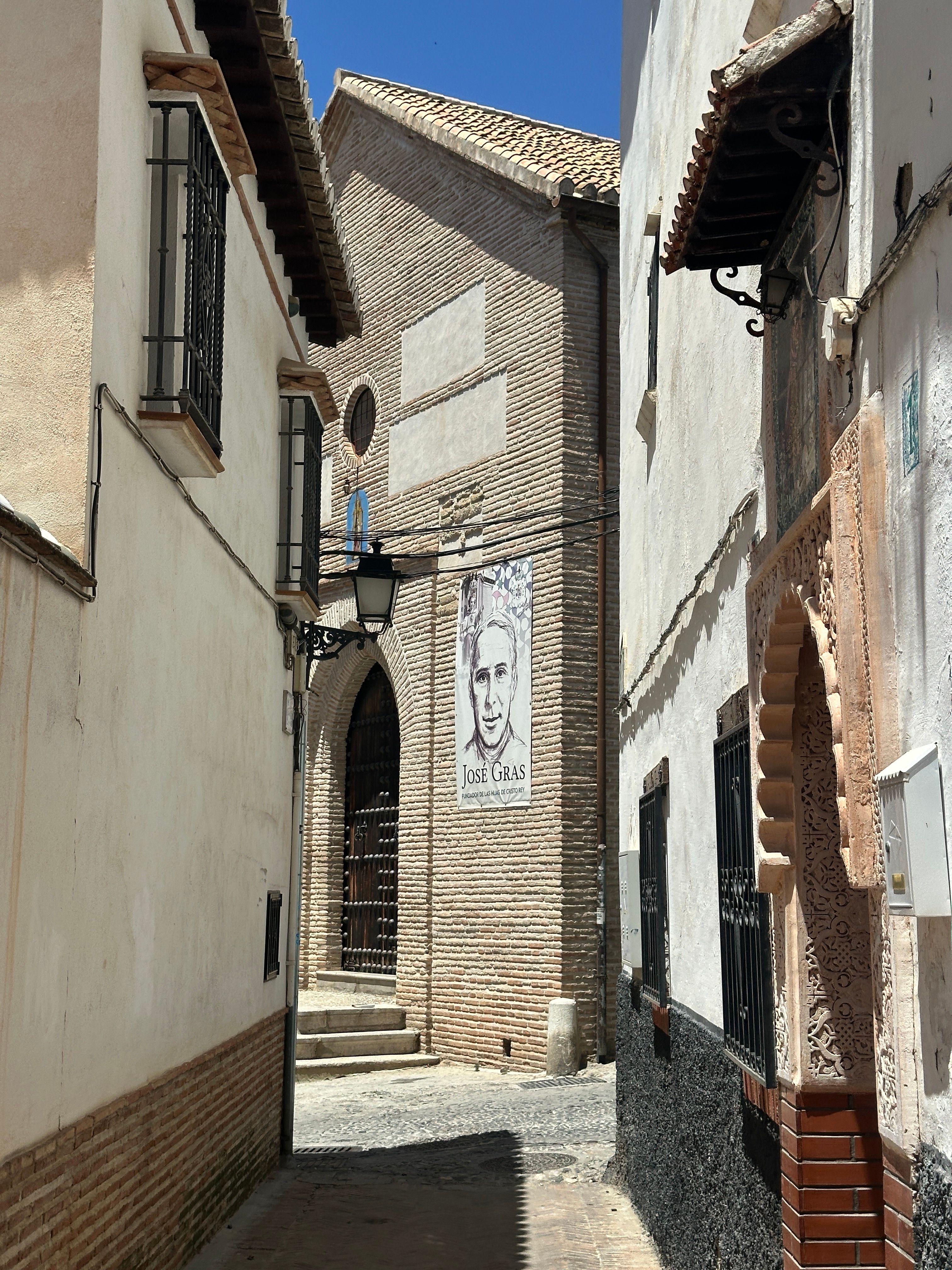 Explore a picturesque narrow street in Granada, featuring traditional architecture and historic charm.