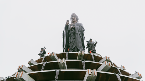 Free A grand statue with intricate sculptures on a temple roof, under a clear sky. Stock Photo