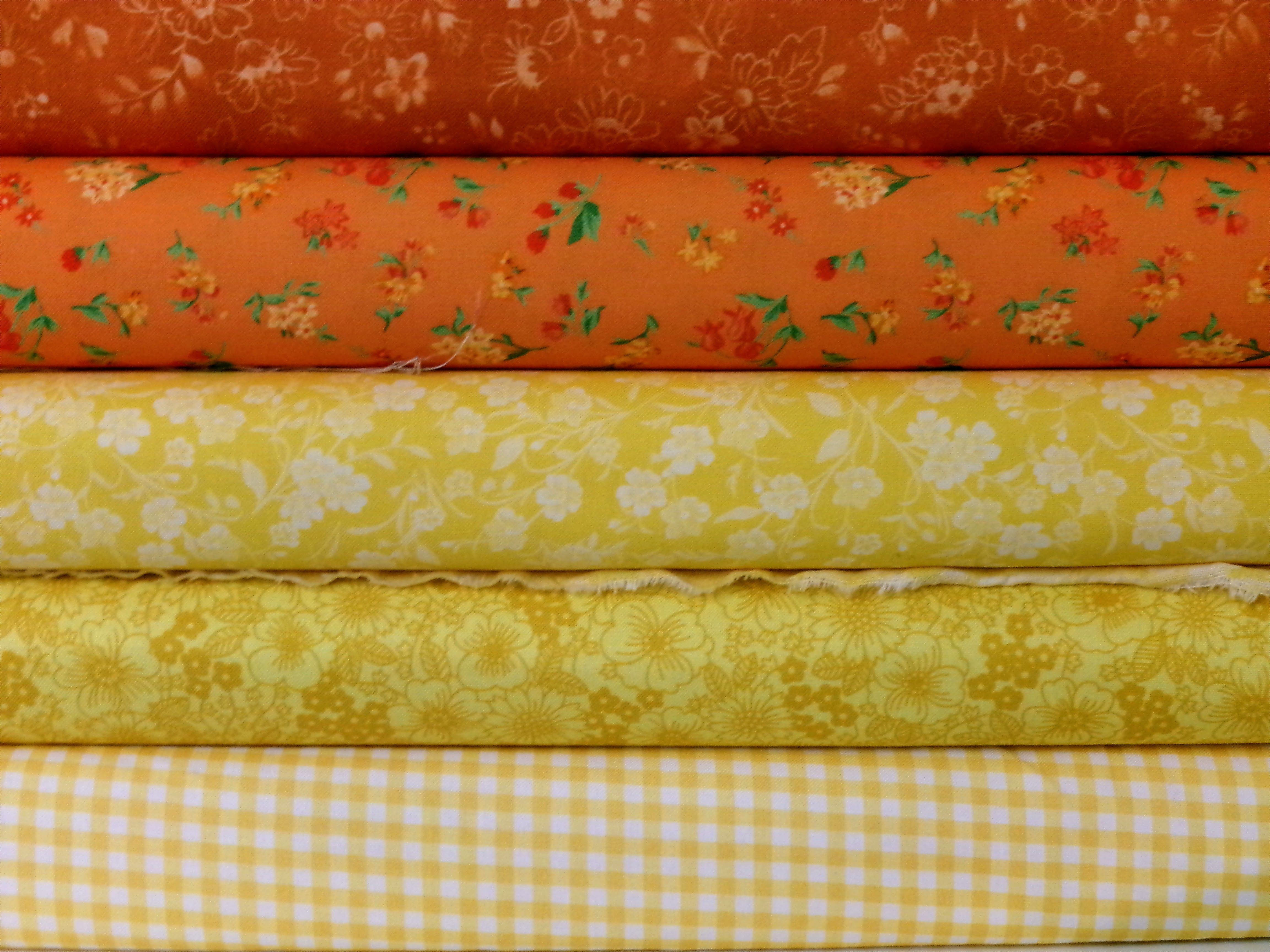 Vibrant floral fabrics stacked, showcasing textures and patterns ideal for crafting projects.