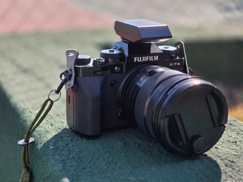 Free Close-up of Fujifilm X-T4 camera on a green surface outdoors, showcasing lens and textured body. Stock Photo