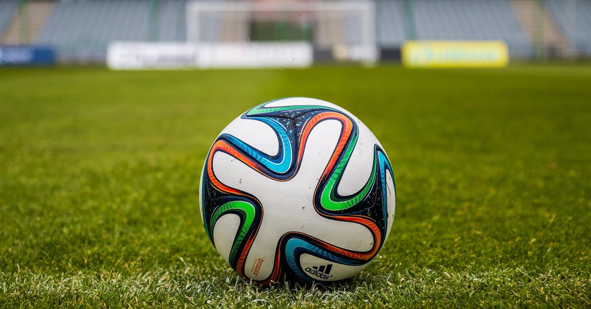 A vibrant adidas soccer ball on a green field, perfect for sports enthusiasts.