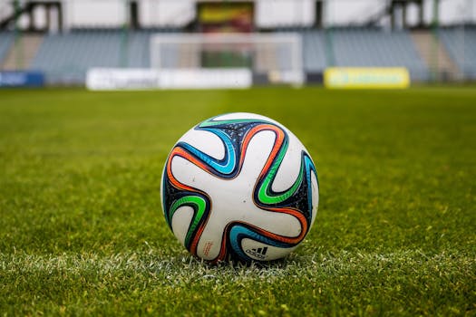 A vibrant adidas soccer ball on a green field, perfect for sports enthusiasts.