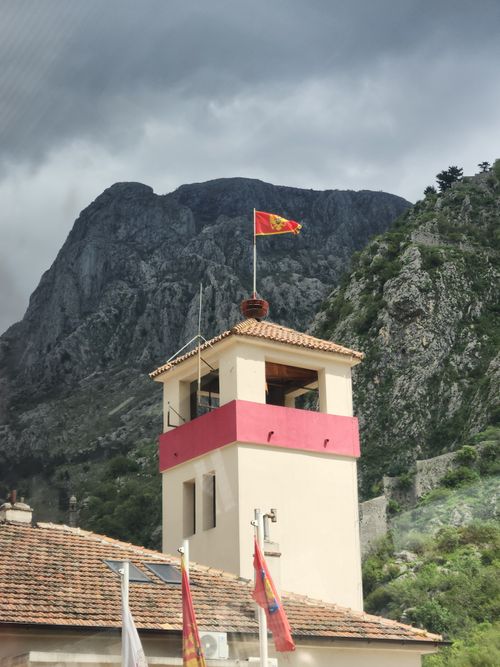 Free A tower with Montenegrin flag against dramatic mountain backdrop. Stock Photo