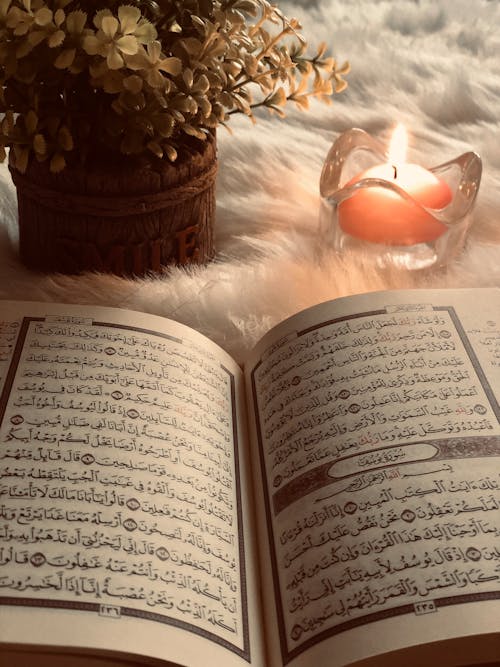  Photo Of An Open Book Beside Red Lighted Candle