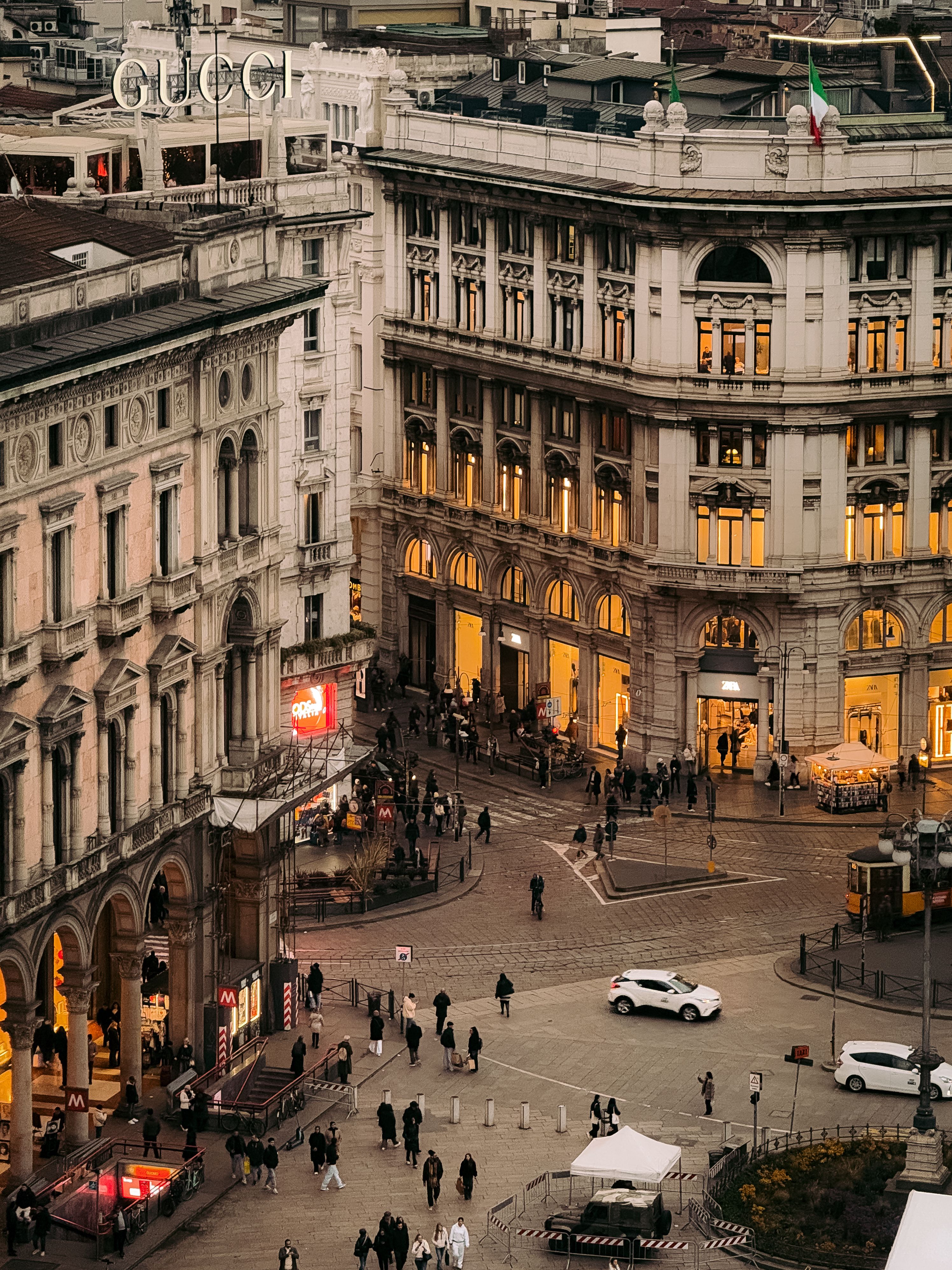 Beautiful aerial view of Milan's historic Piazza with elegant architecture and bustling activity at dusk.