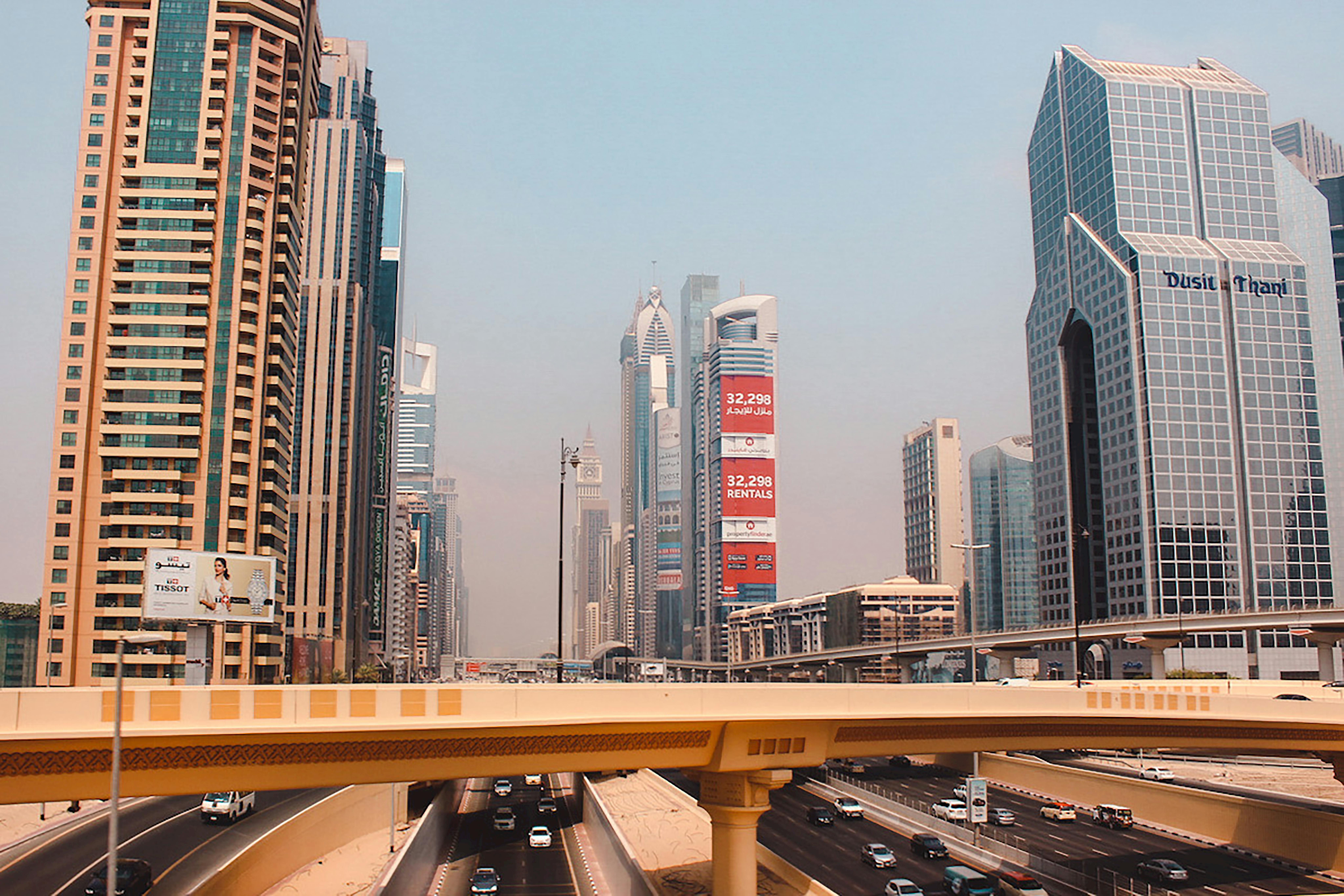 A striking view of modern skyscrapers and an elevated highway in Dubai during the day.