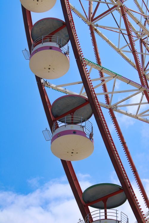 Free Artistic low-angle view of a Ferris wheel with vibrant blue sky in the background. Stock Photo