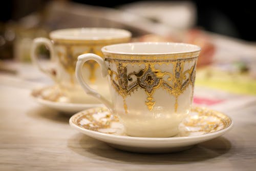 Free White and Golden Ceramic Teacup on Saucer Stock Photo