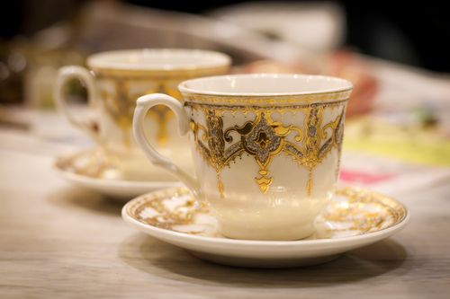 Free A close-up of an ornate porcelain coffee cup with intricate gold patterns in a cozy setting. Stock Photo