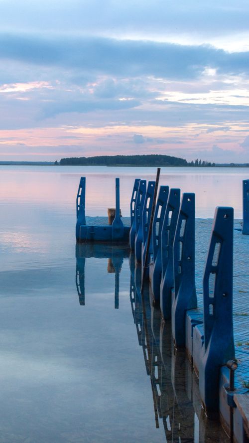 Free Tranquil sunset scene captured over a calm lake with blue docks in Braslav, Belarus. Stock Photo