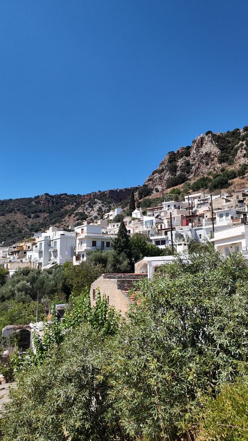 Free Picturesque Kritsa village with whitewashed buildings against a mountainous backdrop in Greece. Stock Photo