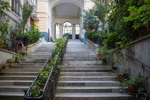 Free Charming stone staircase surrounded by lush greenery in a historic İstanbul courtyard. Stock Photo