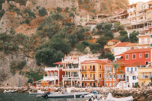 Free Colorful buildings line the waterfront of Parga, Greece, offering a picturesque Mediterranean scene. Stock Photo