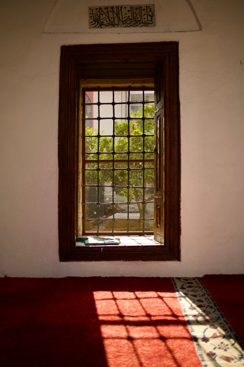 Free Sunlight streaming through a traditional window casting shadows inside a mosque in Adana, Türkiye. Stock Photo