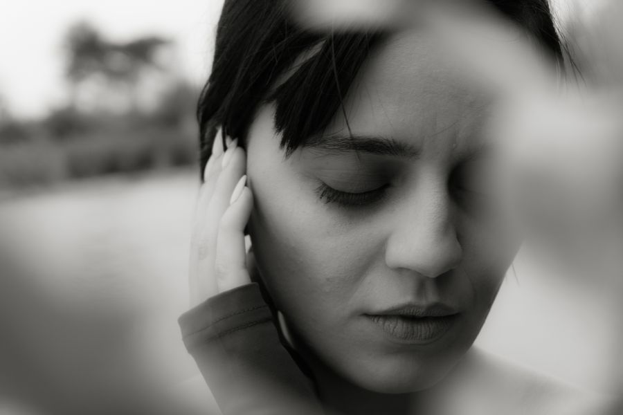 A woman with short dark hair, eyes closed, in monochrome