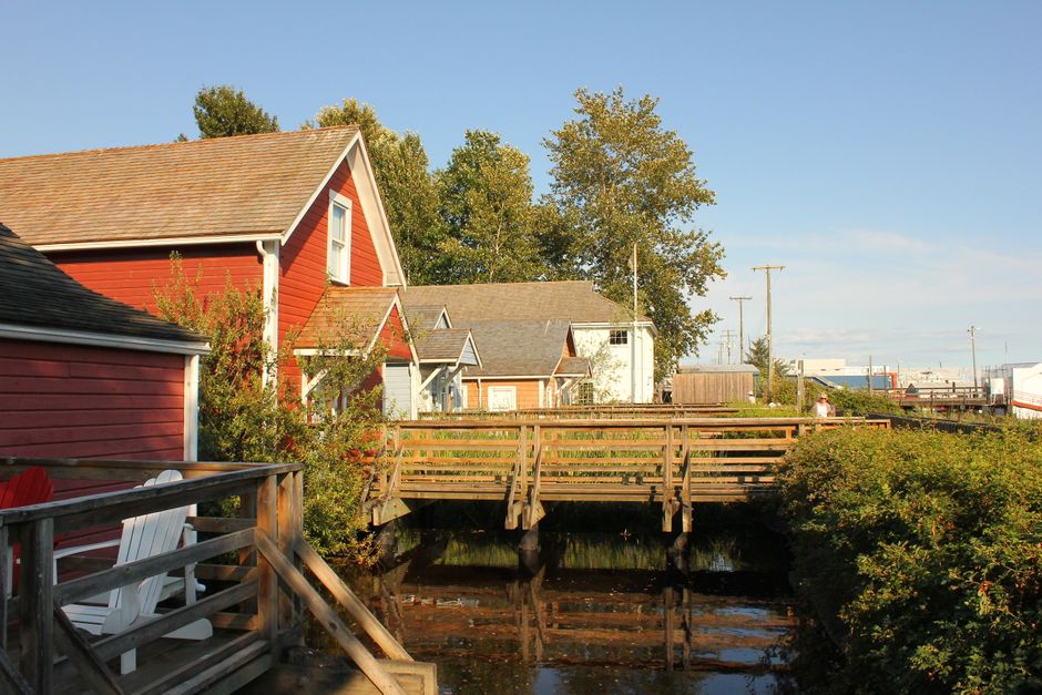 Colorful homes by a wooden bridge in Steveston Village, Richmond, British Columbia, on a sunny day.