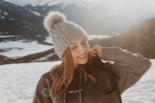 Smiling woman in winter attire enjoying a snowy hike in the Canadian Rockies.