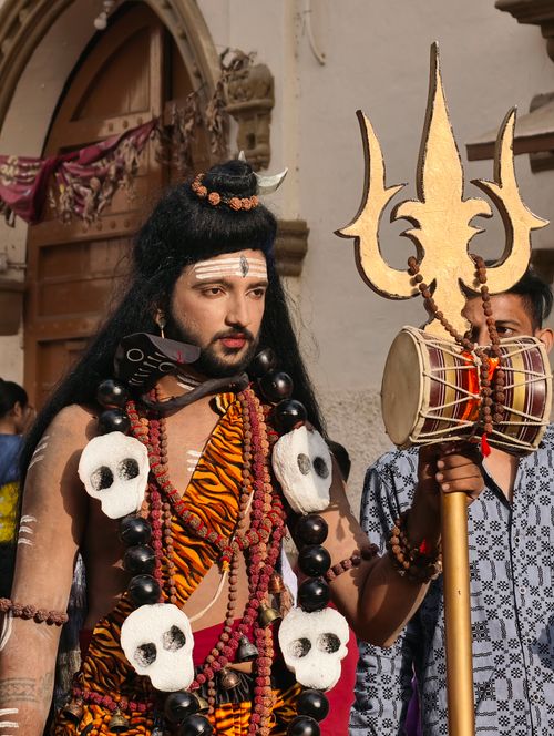 Free A performer in traditional attire, holding a trident at a cultural festival outdoors. Stock Photo