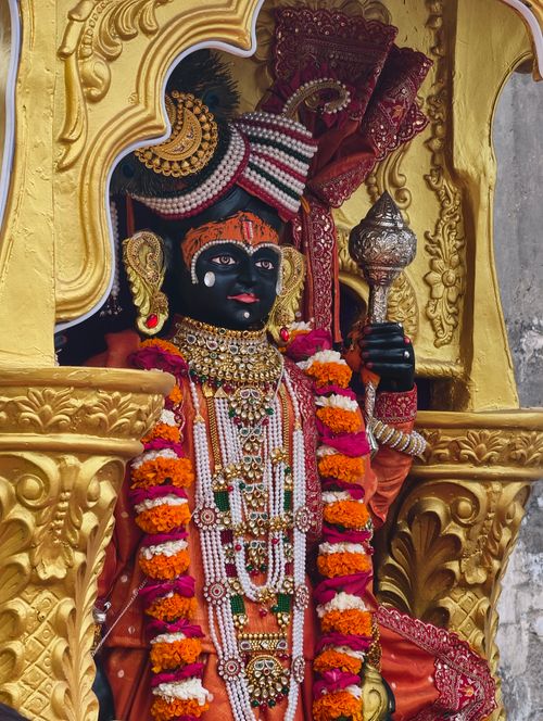 Free Statue of a Hindu deity with elaborate adornments and colorful floral garland. Stock Photo