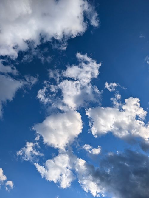 Free Peaceful blue sky scattered with fluffy clouds creating a calming scene. Stock Photo