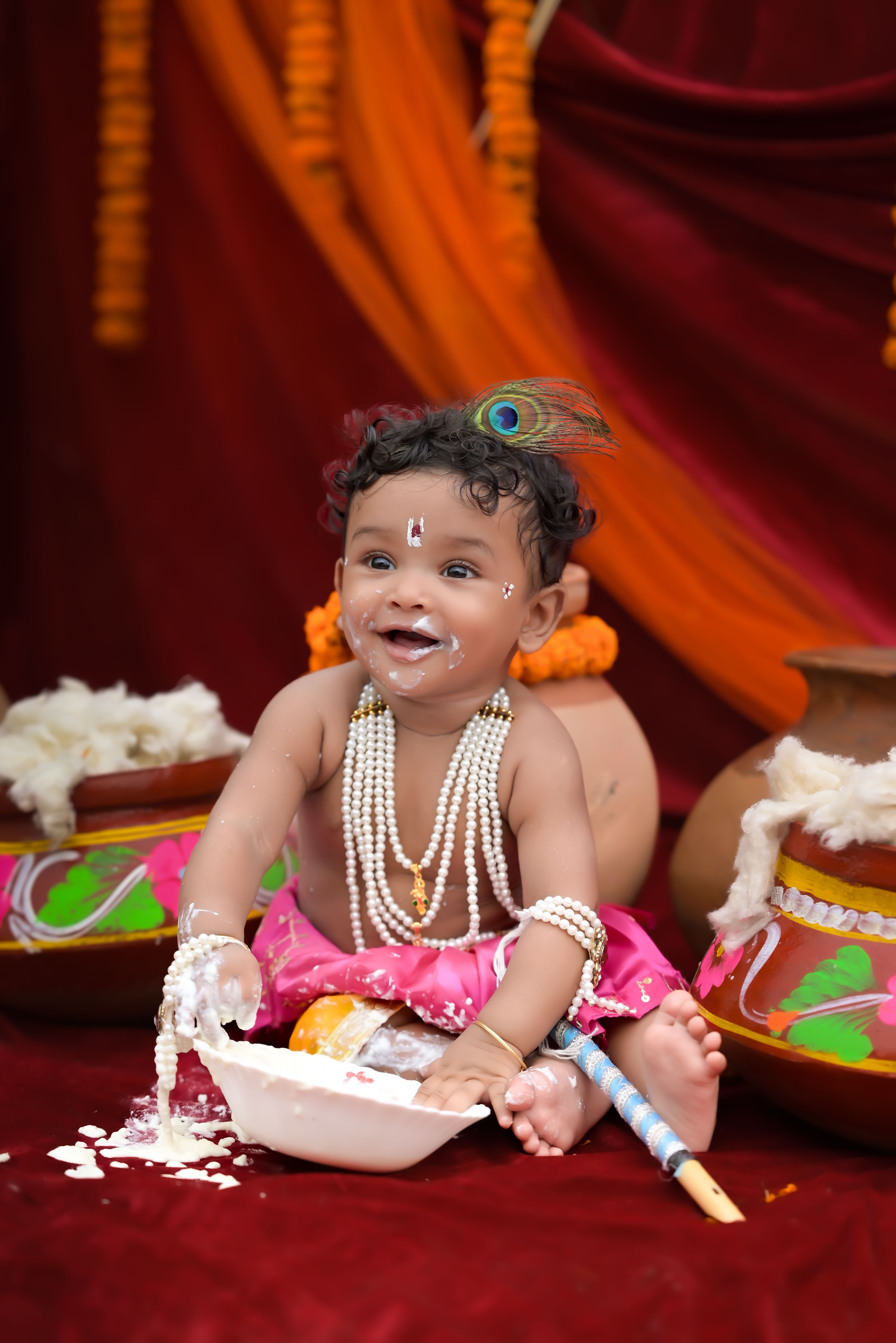Adorable baby in vibrant traditional attire with festive decorations, symbolizing cultural celebration.