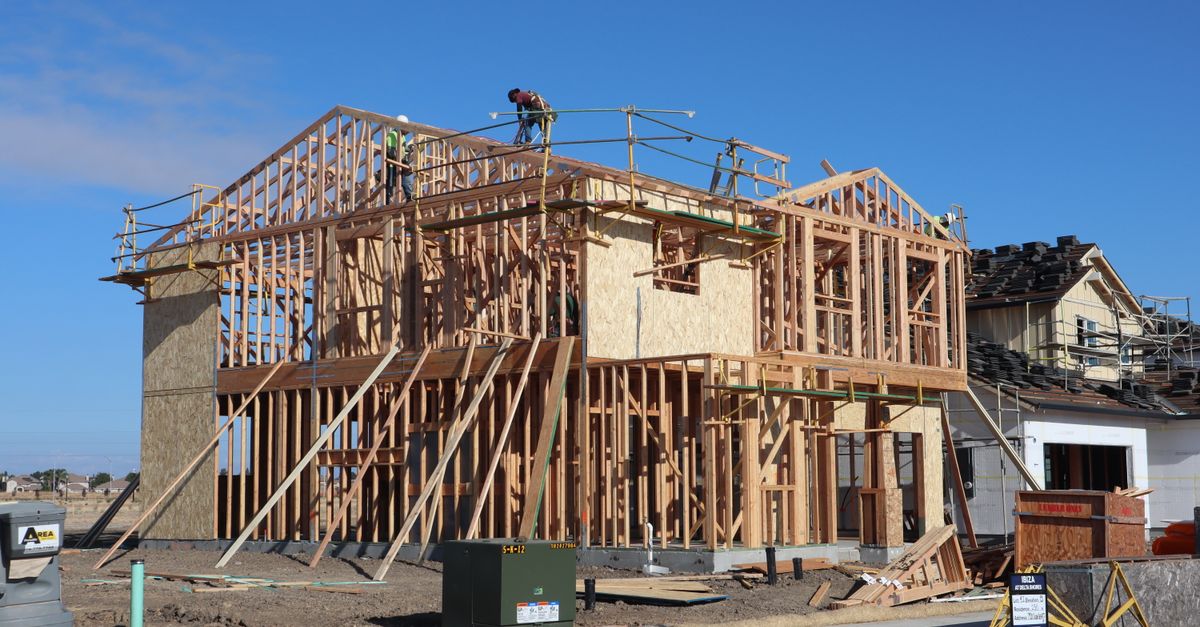 Wood framing of a new house being constructed under a clear blue sky in Sacramento, California.