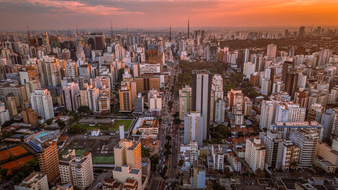 Breathtaking aerial view of São Paulo with skyscrapers under a vibrant sunset sky.