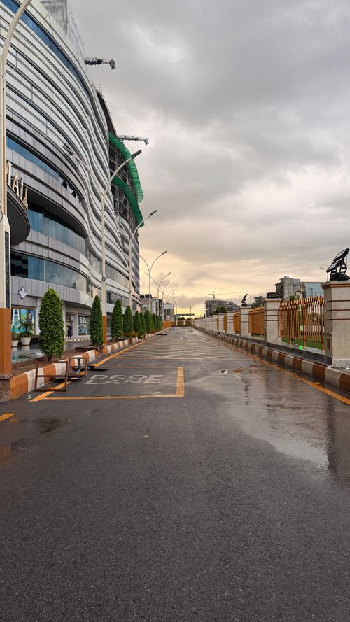 Free A modern urban street reflecting the aftermath of rainfall, showcasing cityscape architecture. Stock Photo
