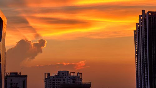 Free Stunning sunset colors illuminate the city skyline, creating a dramatic and vibrant scene. Stock Photo