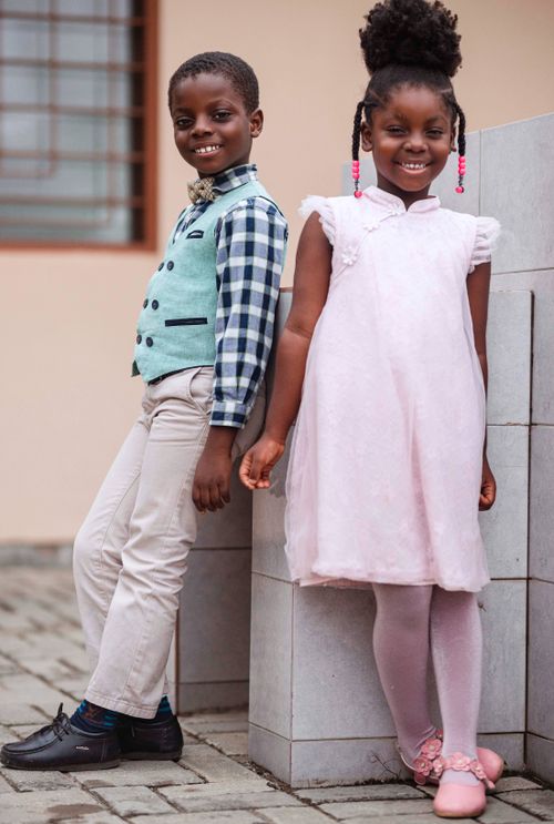 Free Adorable portrait of a cheerful boy and girl in stylish clothing, showcasing youthful elegance. Stock Photo