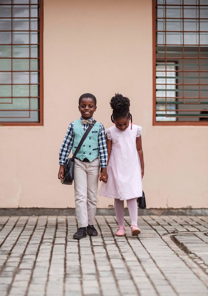 Two children walking hand in hand in Accra, Ghana