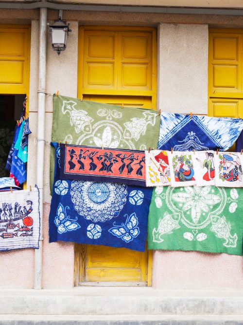 Free Vibrant textiles with intricate patterns displayed on a building facade. Stock Photo