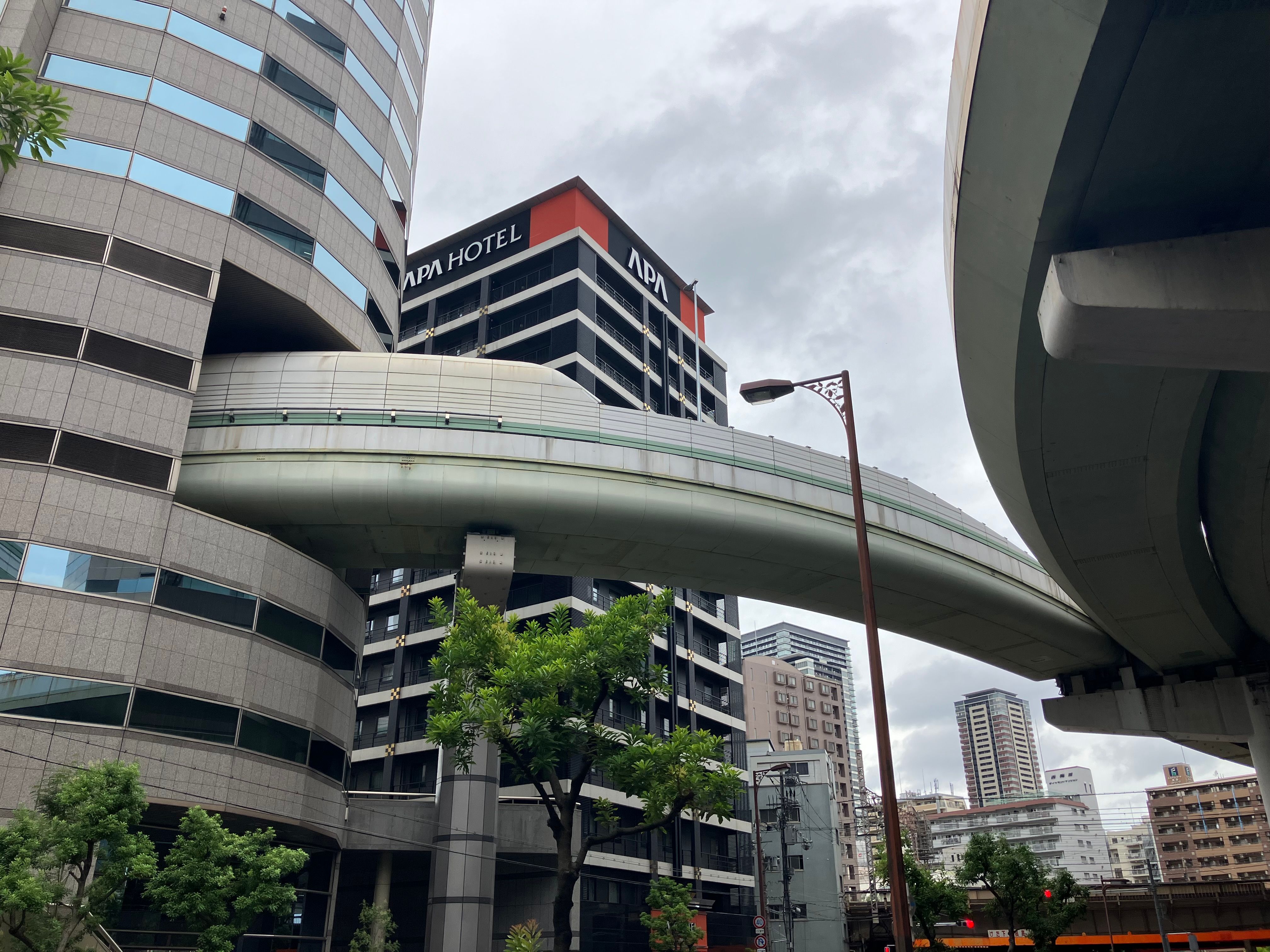 Contemporary architecture featuring a skybridge and APA Hotel in Osaka, Japan.