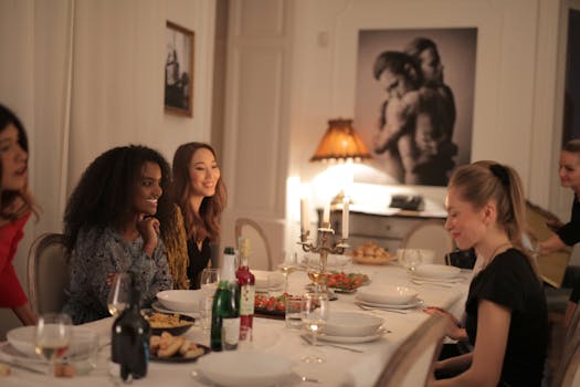 A diverse group of friends enjoying a candlelit dinner indoors, sharing laughter and wine.