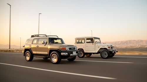 Free Side view of classic and modern SUVs driving on freeway during sunset. Stock Photo