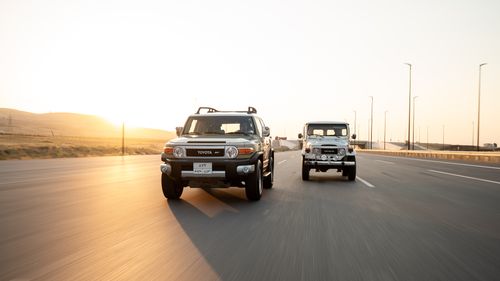 Free Dynamic shot of two Toyota SUVs driving on a highway during sunset, creating a sense of motion. Stock Photo