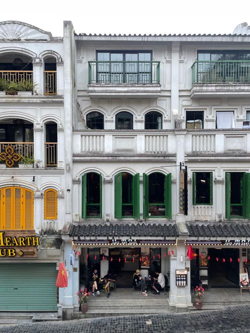 Free Charming colonial architecture on a bustling street in Vietnam, showcasing vibrant colors and local life. Stock Photo