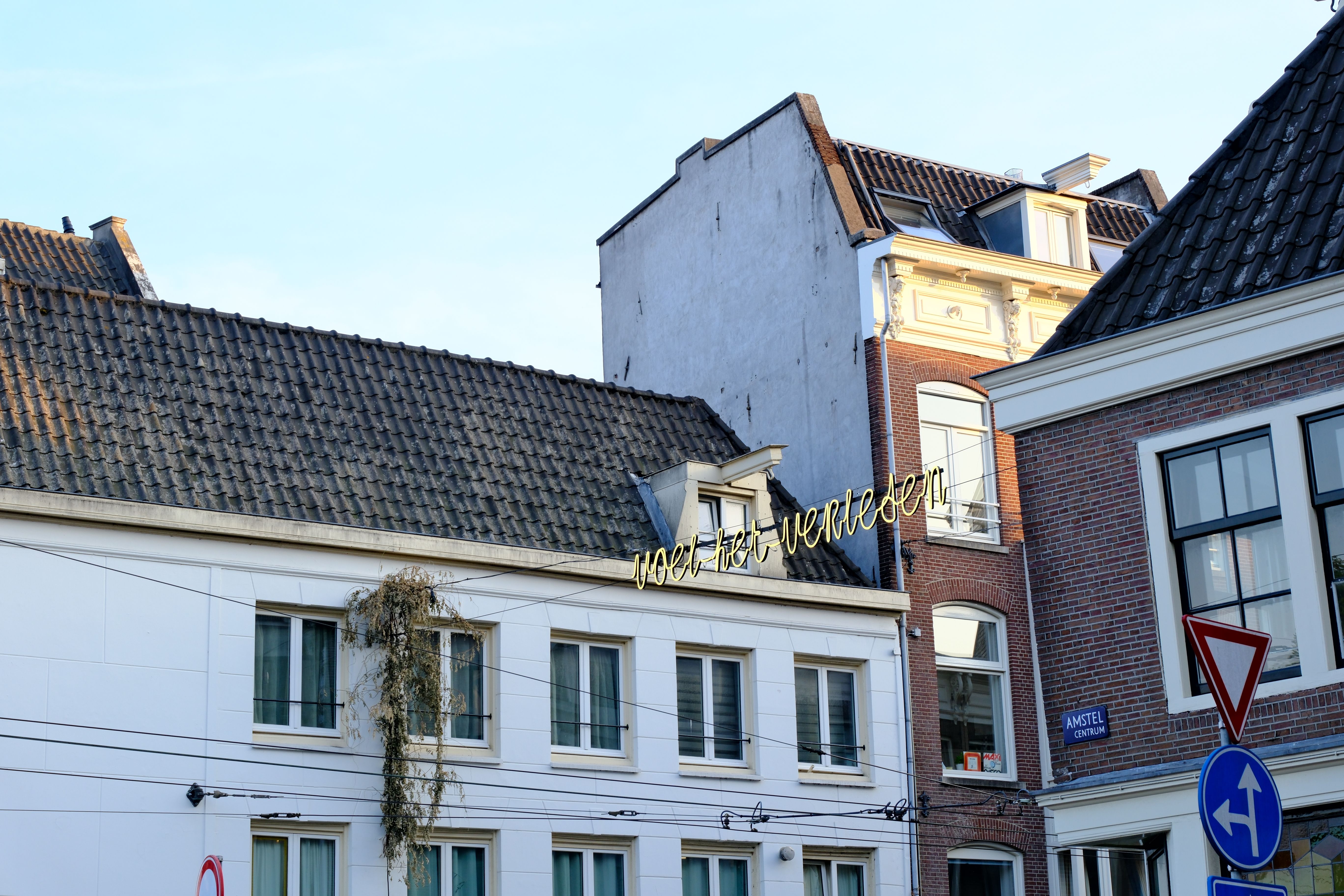 Daylight view of historic European architecture with street signs and rooftop details.