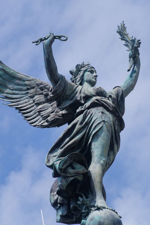Free Majestic angel sculpture at Monument aux Girondins in Bordeaux, France, under a blue sky. Stock Photo