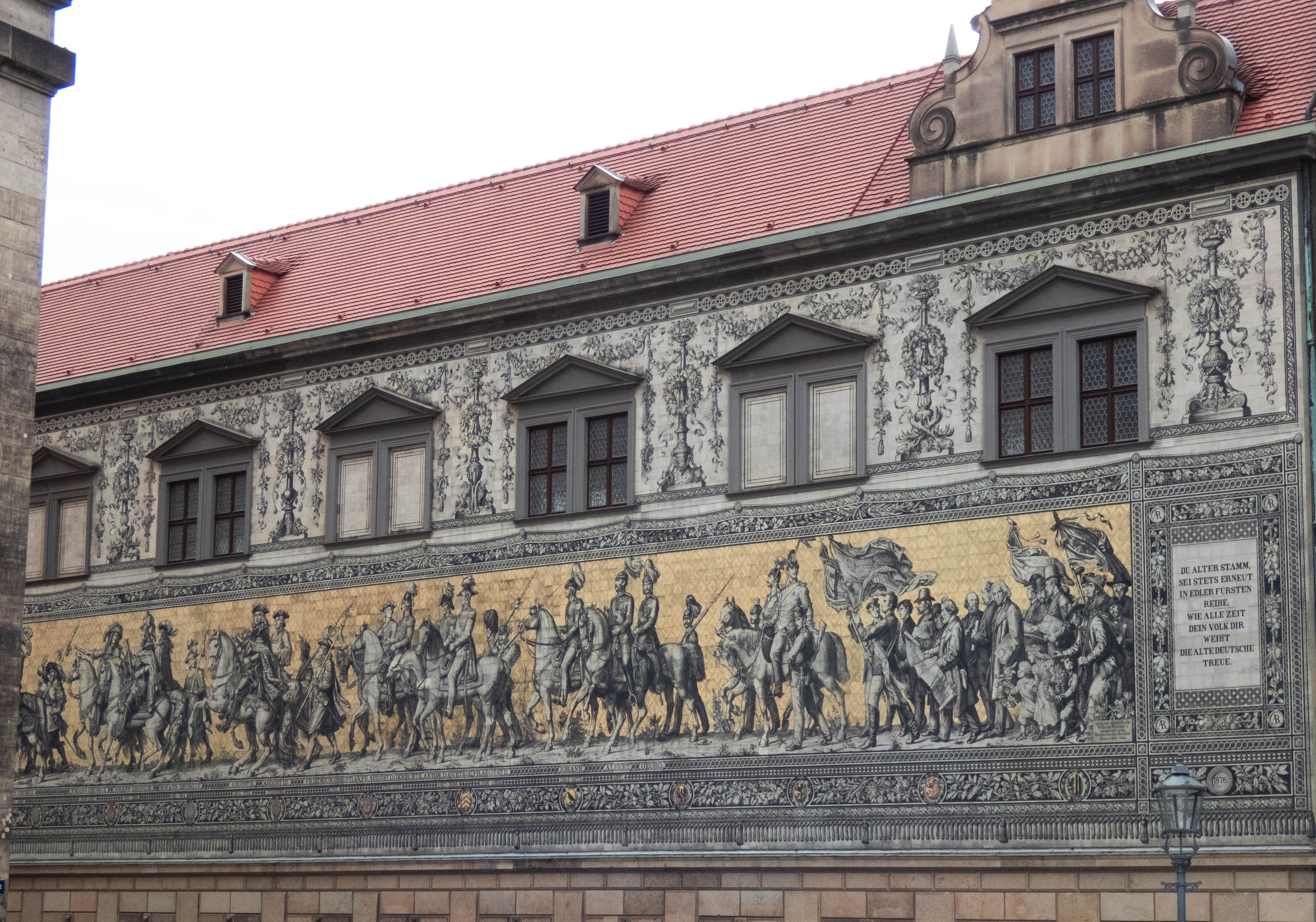 Fotomural El mural Fürstenzug en Dresde muestra figuras históricas con un detalle impresionante en un edificio histórico.