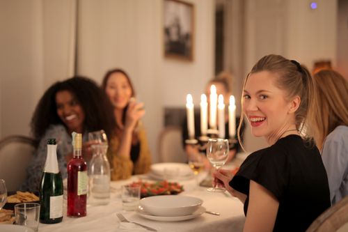 Free A joyful group of women enjoying a candlelit dinner, celebrating friendship indoors. Stock Photo