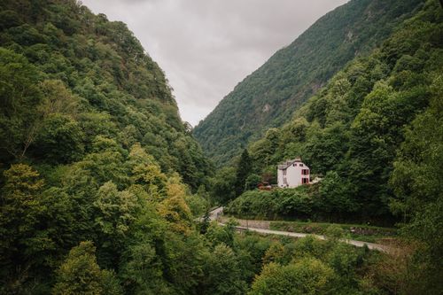 Free A picturesque house nestled between verdant hills in Cauterets, France, under a cloudy sky. Stock Photo